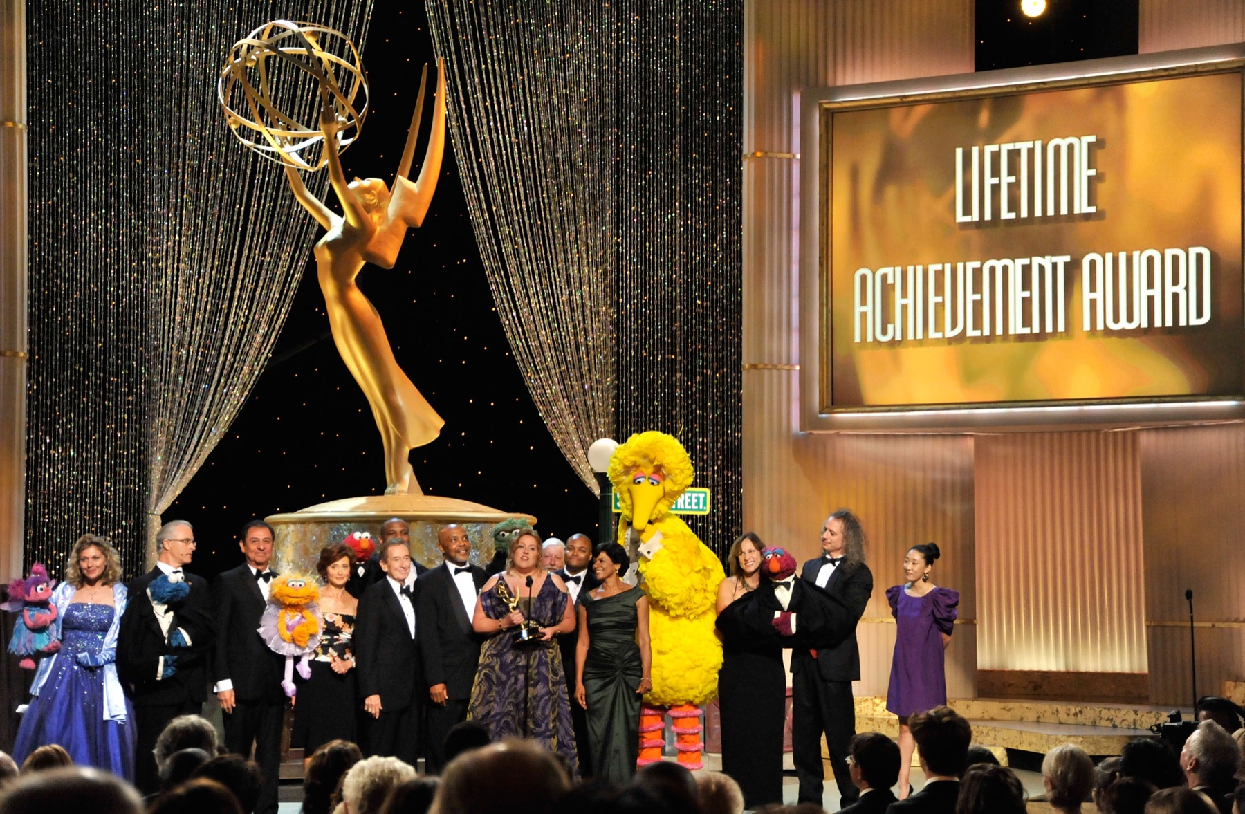 Kevin Clash and the Sesame Street company gathered on an awards stage